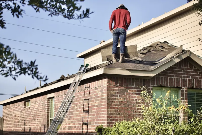 Professional roofer working on a residential roof in Chesmar